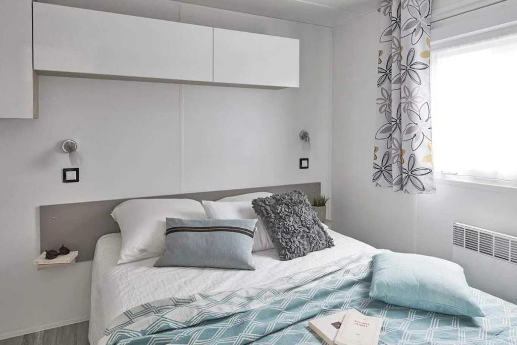 une chambre blanche avec un lit et une fenêtre dans l'établissement Camping 4 étoiles - Piscine - ef0ihh, à Proissans 37 autres photos