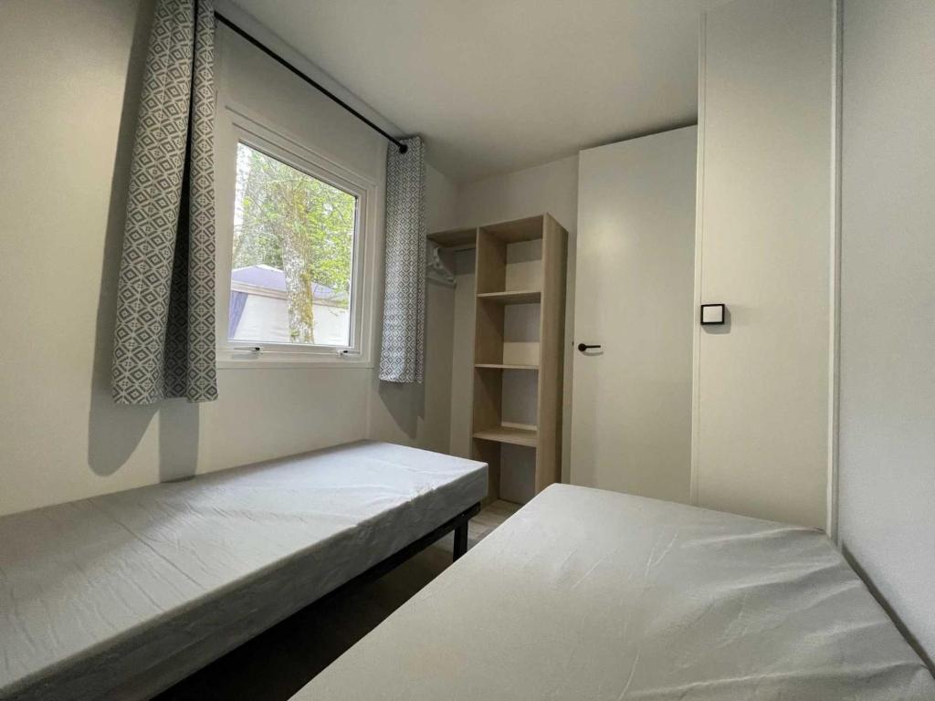 une petite chambre avec deux lits et une fenêtre dans l'établissement Camping 4 étoiles - Piscine - ef0ihh, à Proissans