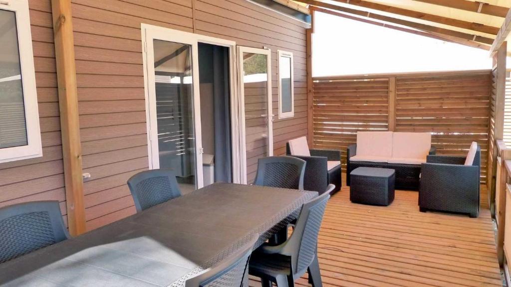un patio avec une table et des chaises sur une terrasse dans l'établissement Camping 4 étoiles - Parc aquatique - efacff, à Hyères