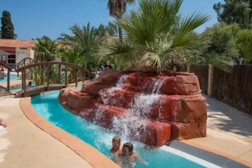 2 enfants jouant sur un toboggan dans un complexe dans l'établissement Camping 4 étoiles - Parc aquatique - efacff, à Hyères