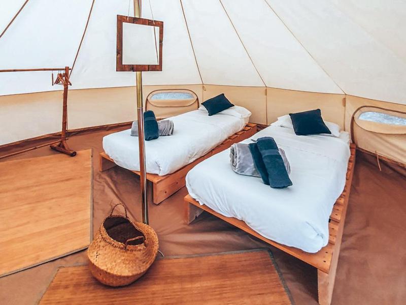 une chambre avec deux lits dans une tente dans l'établissement Lodg'ing Nature Camp Dordogne, à Lacave