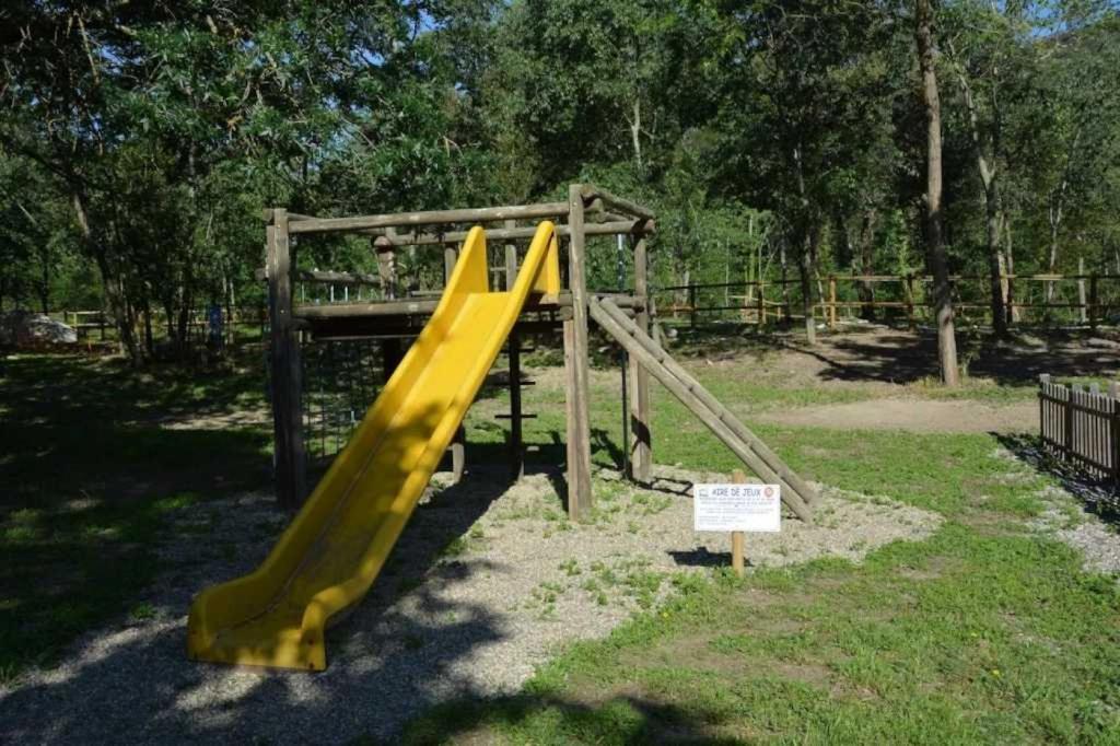 une aire de jeux avec toboggan jaune dans un parc dans l'établissement Camping 3 étoiles - Piscine - ccaaafi, à Arles-sur-Tech
