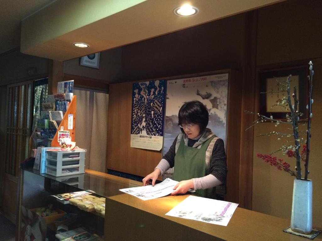 une femme debout à un comptoir dans un magasin dans l'établissement Yudanaka Onsen Yamazakiya, à Yamanouchi 37 autres photos