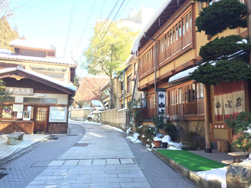 une rue vide dans une ville asiatique avec des bâtiments dans l'établissement Yudanaka Onsen Yamazakiya, à Yamanouchi