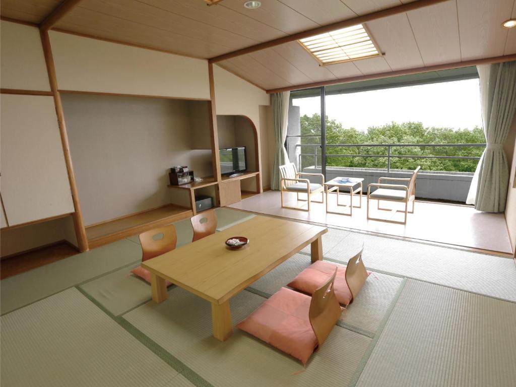 un salon avec une table et des chaises et un balcon dans l'établissement Villa Inawashiro, à Inawashiro