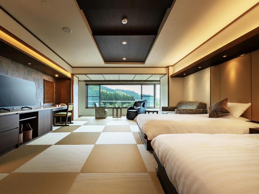 Cette chambre comprend 3 lits et une télévision à écran plat. dans l'établissement Zao Shiki no Hotel, à Zao Onsen