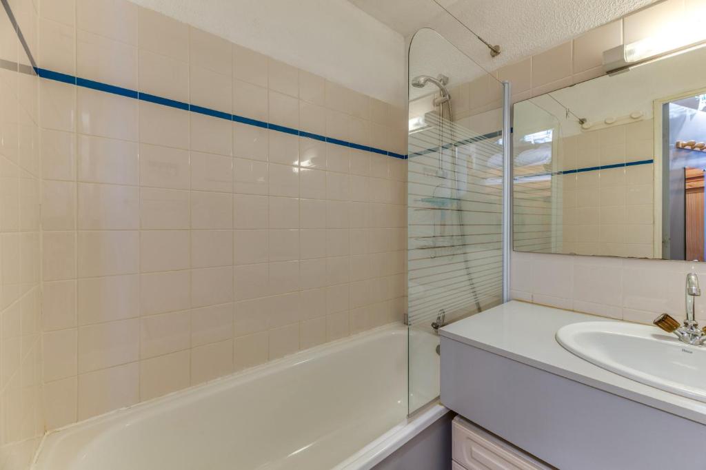 une salle de bain avec une baignoire, un lavabo et un miroir dans l'établissement Granges 25 - Au Pied Des Pistes, à Villard-Reculas 9 autres photos