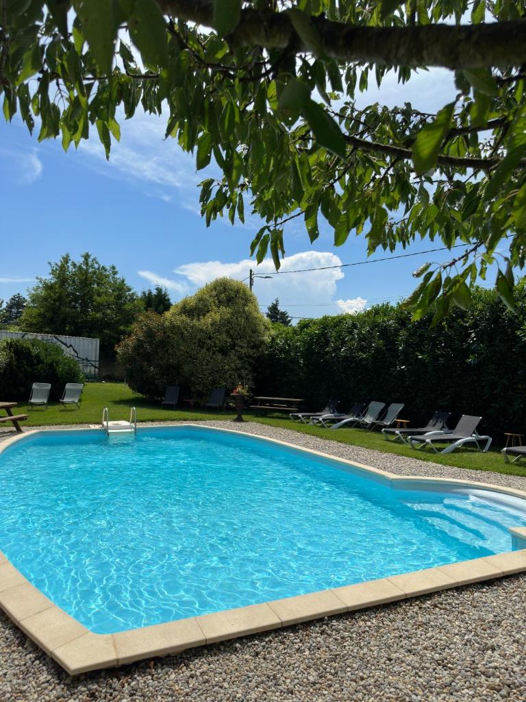 - une piscine dans une cour avec des chaises et des arbres dans l'établissement Gite du Facteur, à Lens-Lestang