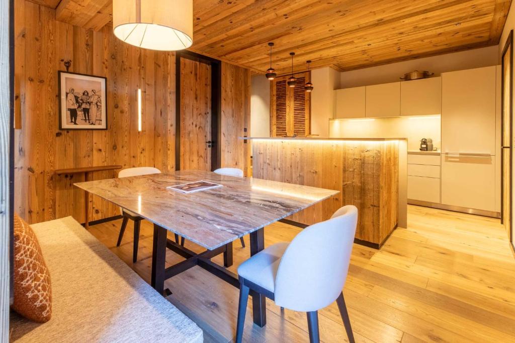 une cuisine et une salle à manger avec une table et des chaises en bois dans l'établissement Antarès Sirius 001, à Méribel