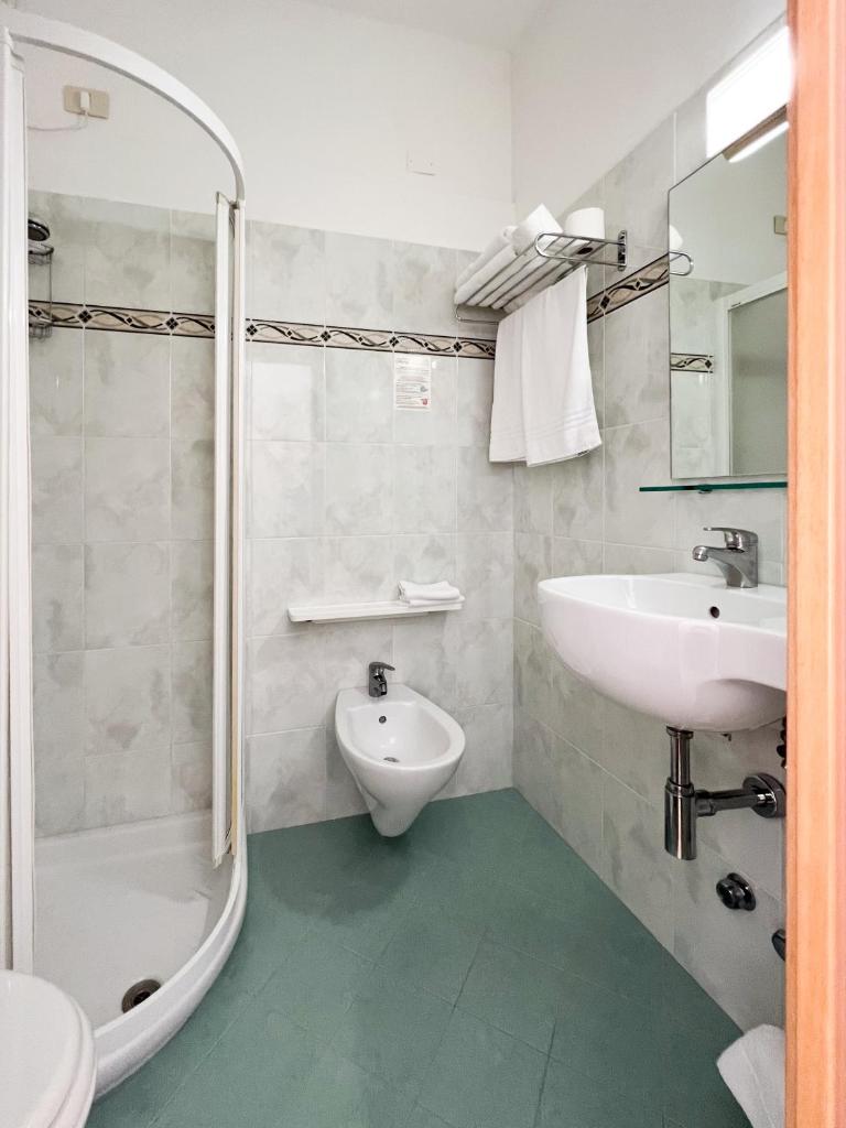 une salle de bain blanche avec lavabo et douche dans l'établissement Hotel Chery, à Milano Marittima 58 autres photos