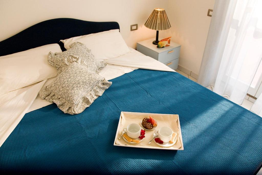 - un plateau de nourriture assis au-dessus d'un lit dans l'établissement Residence I Giardini Del Conero, à Porto Recanati