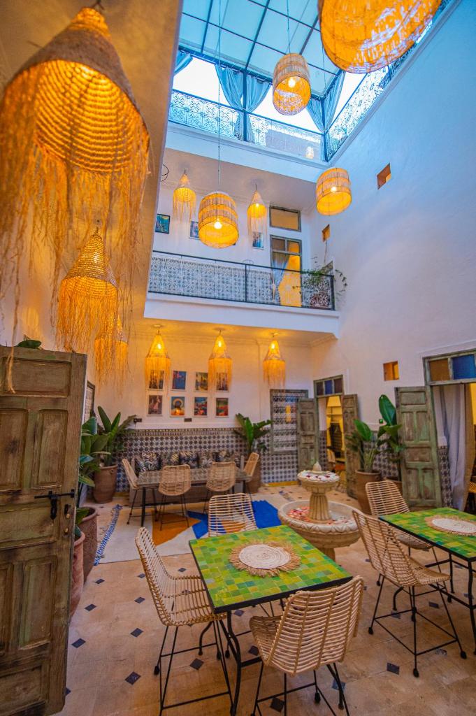 une grande chambre avec des tables, des chaises et des lumières dans l'établissement Riad Bab Taghzout Marrakech, à Marrakech