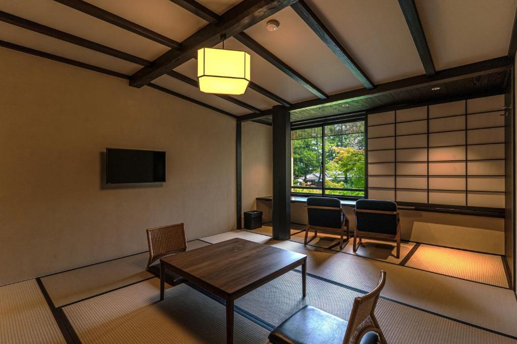 une pièce avec une table, des chaises et une fenêtre dans l'établissement Taikyourou, à Miyazu