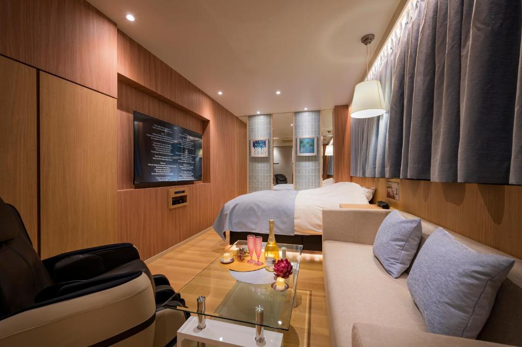 une chambre d'hôtel avec un lit et un canapé dans l'établissement ハッピーキス双葉店, à Kai