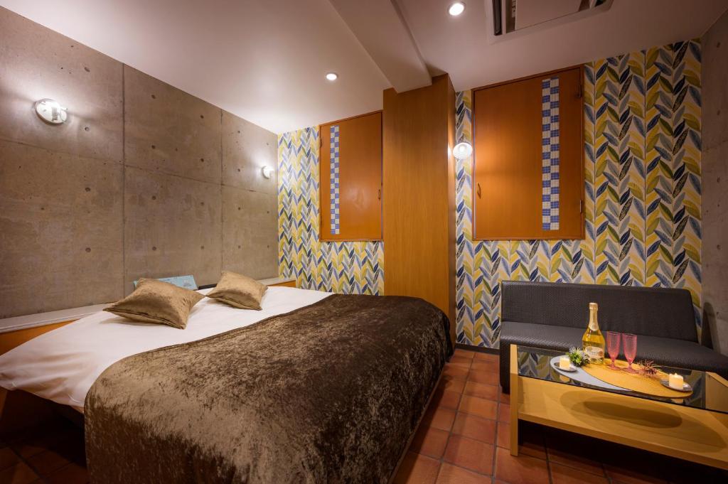 une chambre avec un grand lit et une table dans l'établissement ハッピーキス双葉店, à Kai