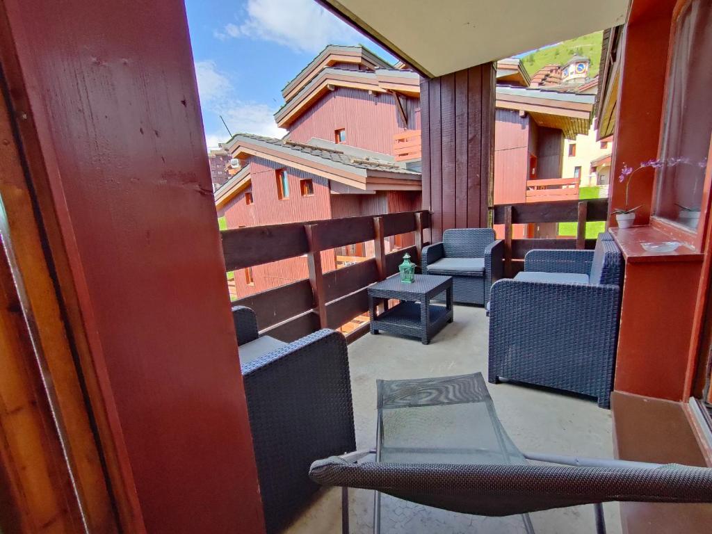 un balcon avec des chaises et des tables sur un immeuble dans l'établissement Appartement 5 p Belle Plagne Skis aux pieds, à Belle Plagne