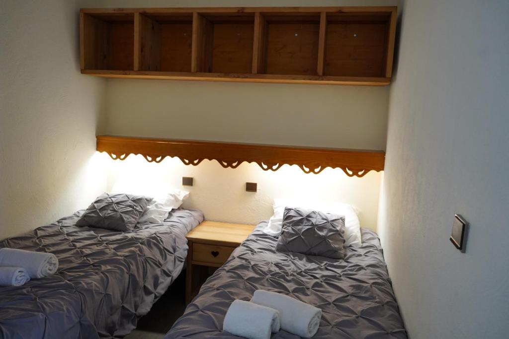- une chambre avec 2 lits, un bureau et des armoires dans l'établissement Résidence Montana Premier, à Val Thorens