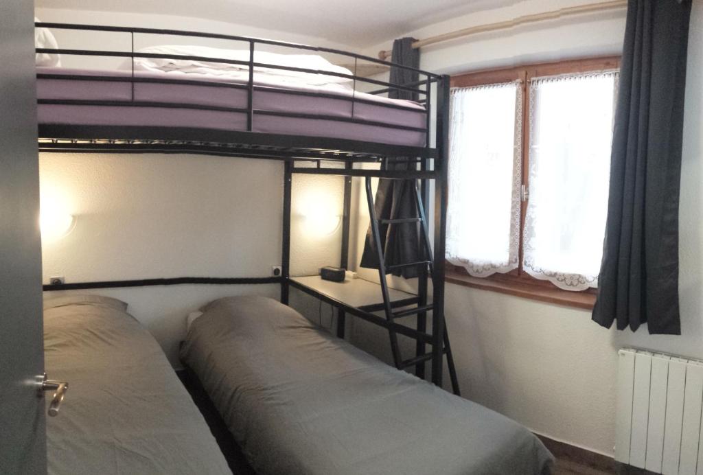 une chambre avec deux lits superposés et une fenêtre dans l'établissement Superbe appartement en résidence skis aux pieds, à Courchevel 3 autres photos