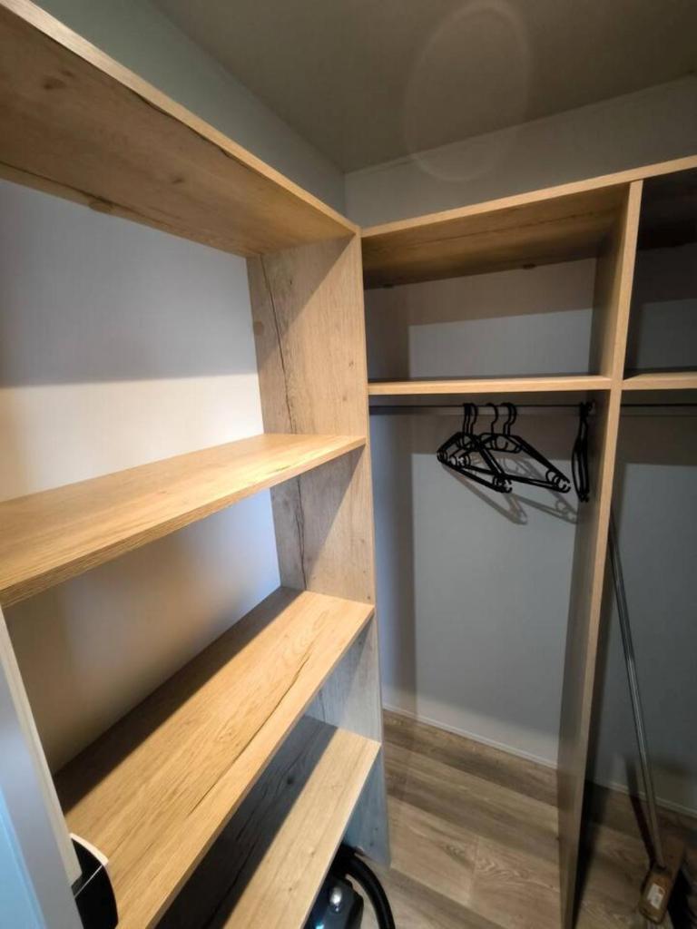 d'une armoire avec des étagères en bois. dans l'établissement Charme, Confort & Espace, 3 ch, 40 m2, super équipé, à Lattes