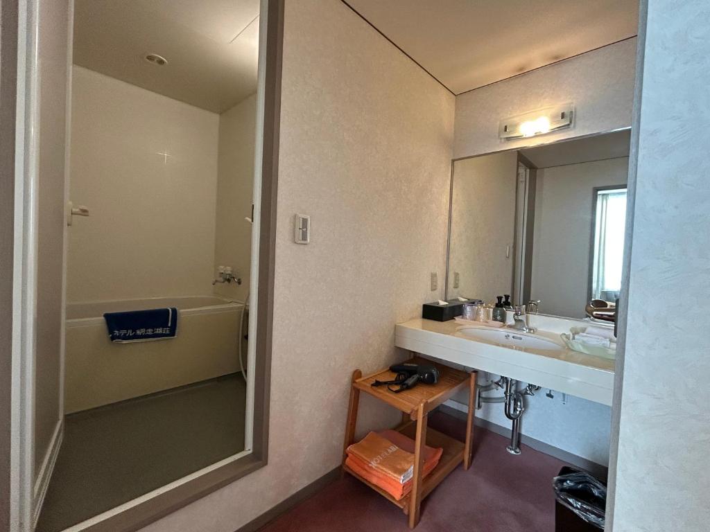 une salle de bain avec un lavabo et un miroir dans l'établissement Hotel Abashirikoso, à Abashiri