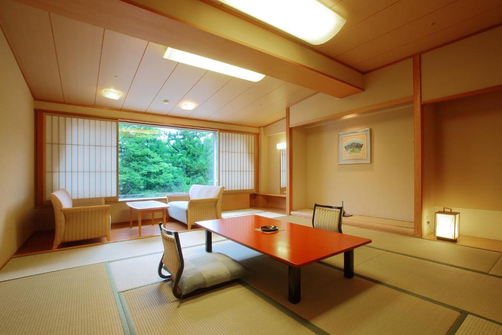 une pièce avec une table, des chaises et une fenêtre dans l'établissement Hotel New Mitoya, à Sendai