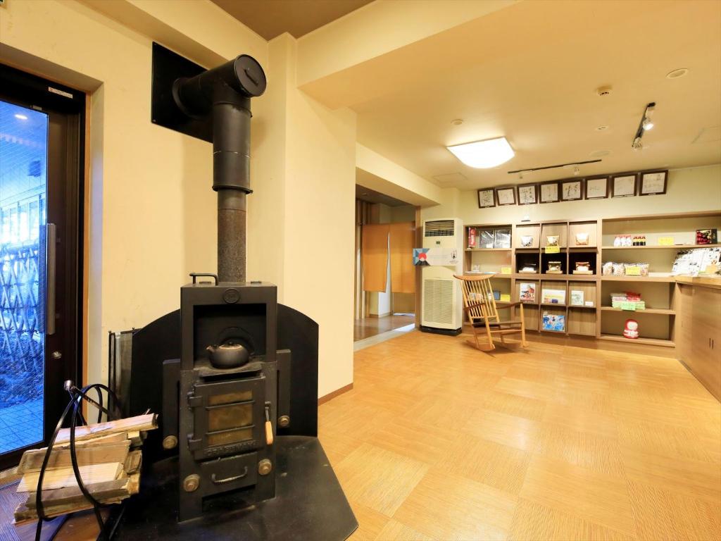 un salon avec un poêle à bois dans une pièce dans l'établissement Hamabeno Ryouriyado Houraikan, à Kamaishi