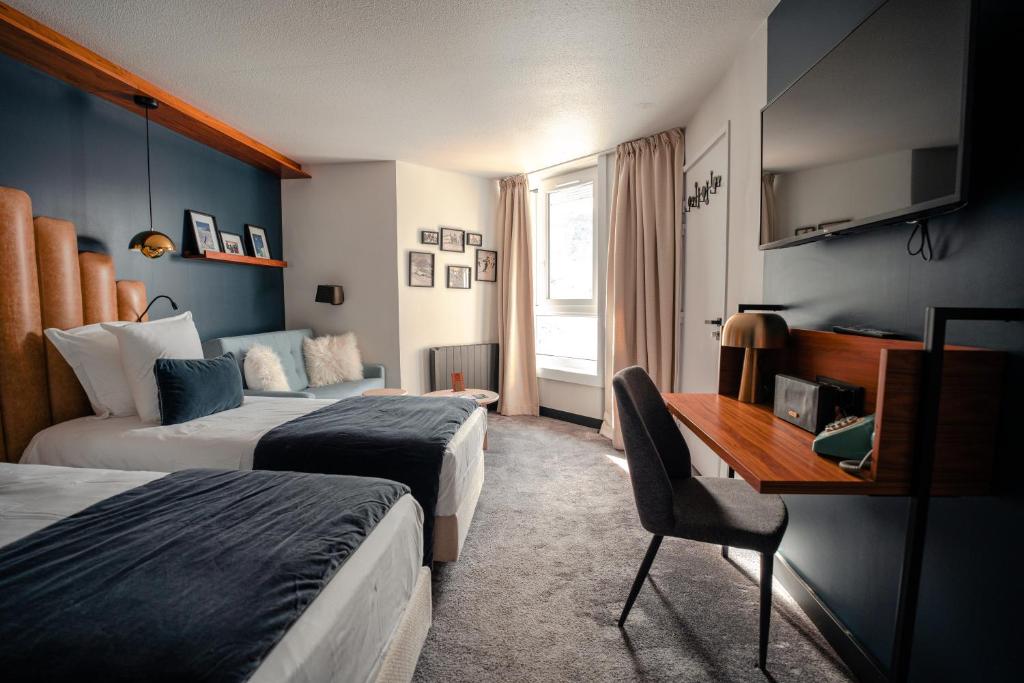 une chambre d'hôtel avec deux lits et un bureau dans l'établissement Fahrenheit Seven Val Thorens, à Val Thorens
