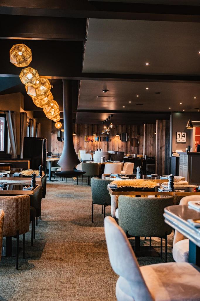 un restaurant avec des tables et des chaises et un bar dans l'établissement Fahrenheit Seven Courchevel, à Courchevel