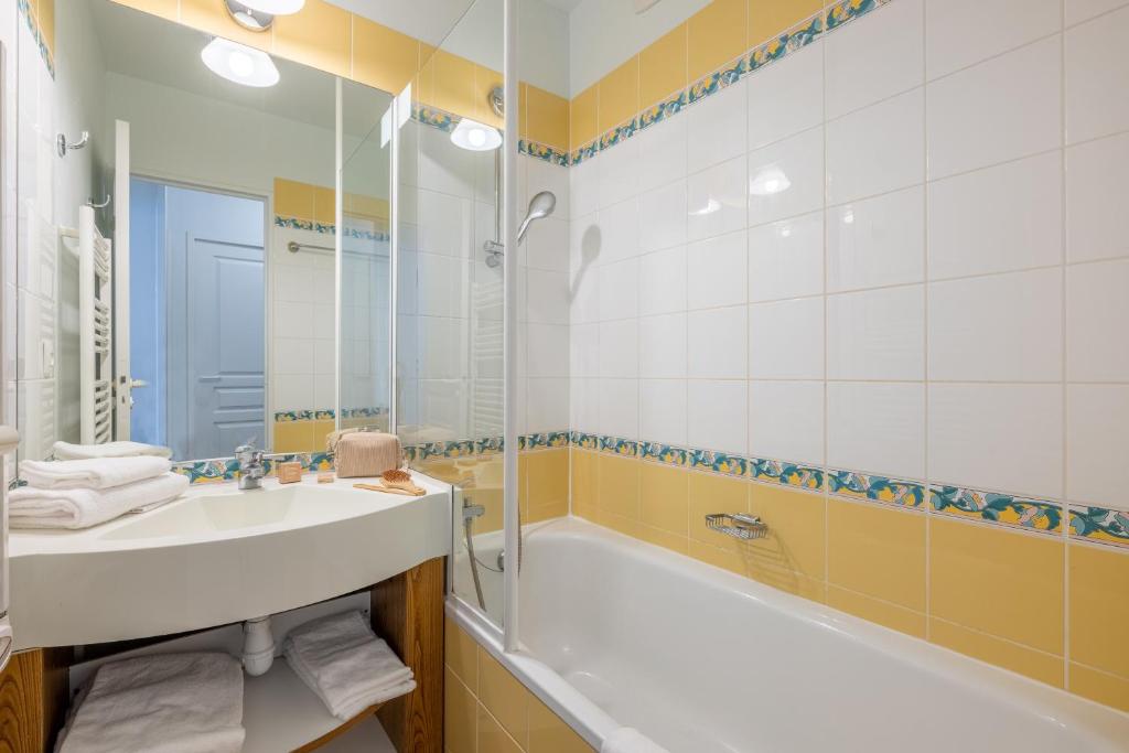 une salle de bain avec un lavabo, une baignoire et une douche dans l'établissement Résidence Pierre & Vacances Le Thabor, à Valmeinier