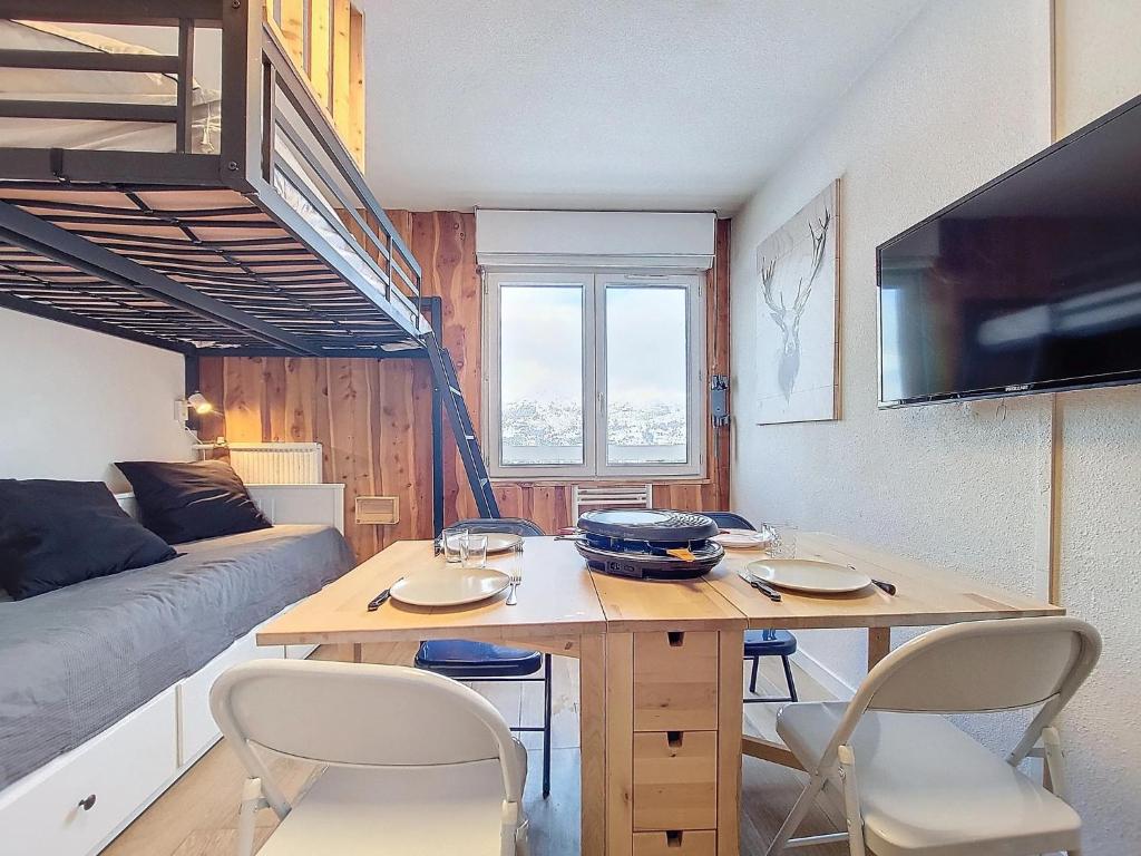 un petit appartement avec une table et des chaises dans une pièce dans l'établissement Studio chaleureux rénové au pied des pistes, à Saint-Étienne-en-Dévoluy