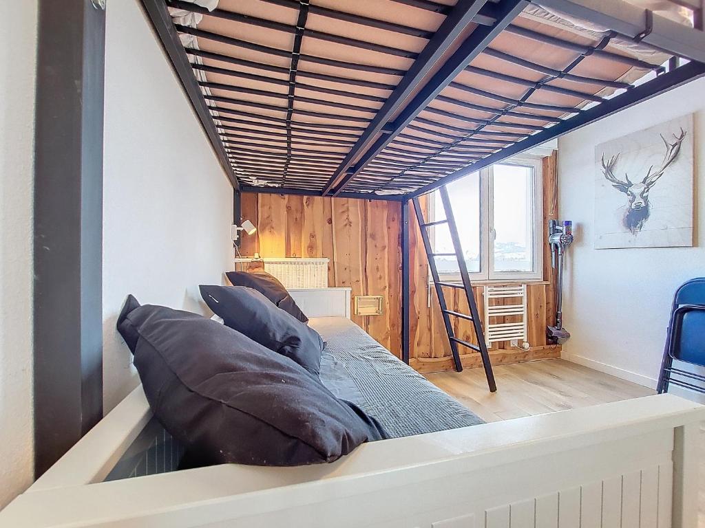 Cette chambre comprend un lit avec des oreillers. dans l'établissement Studio chaleureux rénové au pied des pistes, à Saint-Étienne-en-Dévoluy 2 autres photos