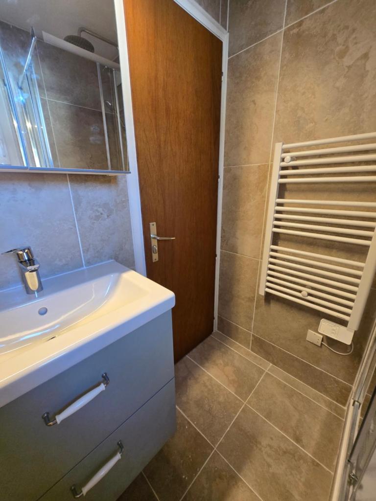 une salle de bain avec un lavabo et une douche dans l'établissement Les Brimbelles 27 studio au pied du télémix de Belle Étoile, à Les Deux Alpes 10 autres photos