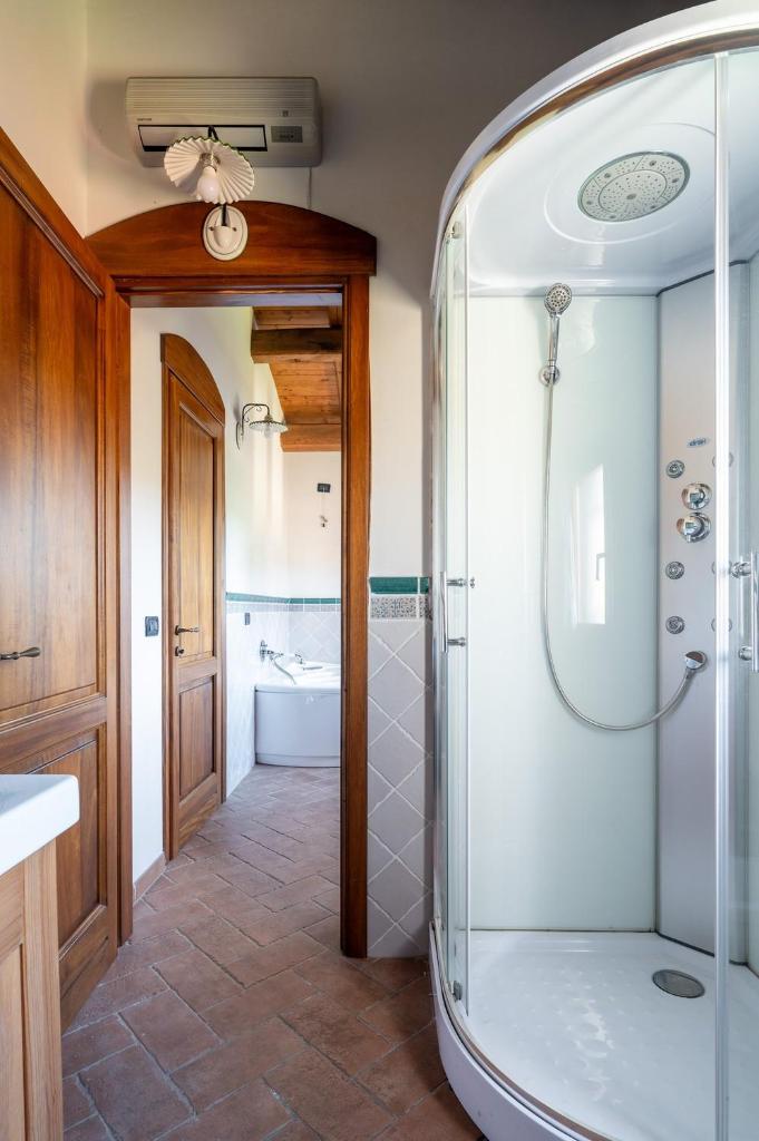 une salle de bain avec une douche avec une porte vitrée dans l'établissement Villa Calyra by Klodge, à Olbia