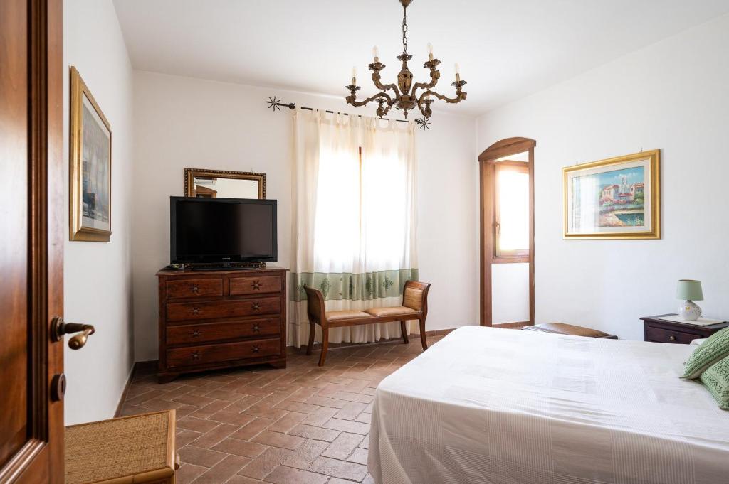 une chambre avec un lit et une télévision sur une commode dans l'établissement Villa Calyra by Klodge, à Olbia