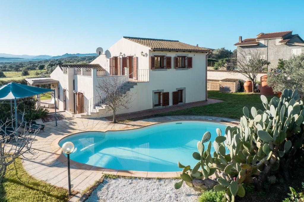 une villa avec piscine devant une maison dans l'établissement Villa Calyra by Klodge, à Olbia