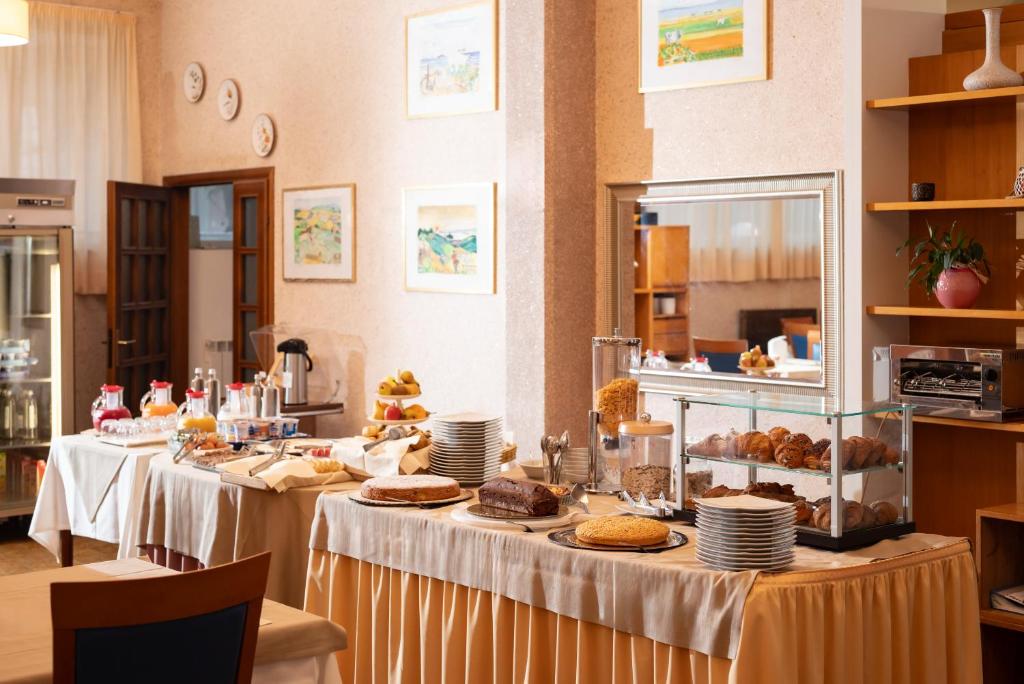 une rangée de tables de buffet avec de la nourriture dessus dans l'établissement Hotel Parco dei Pini - 100mt dal Mare, à Follonica