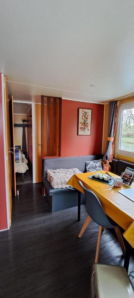 un salon avec un canapé et une table dans l'établissement Cottage flottant Saint Jean de Losne option jacuzzi, à Saint-Jean-de-Losne