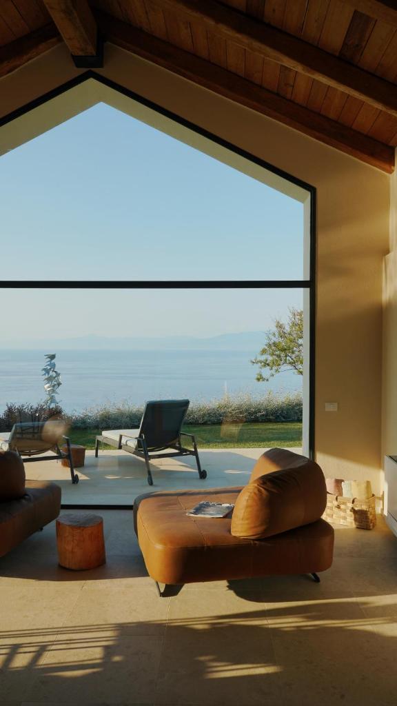 un salon avec une grande fenêtre avec un canapé dans l'établissement JATU Retreat, à San Costantino