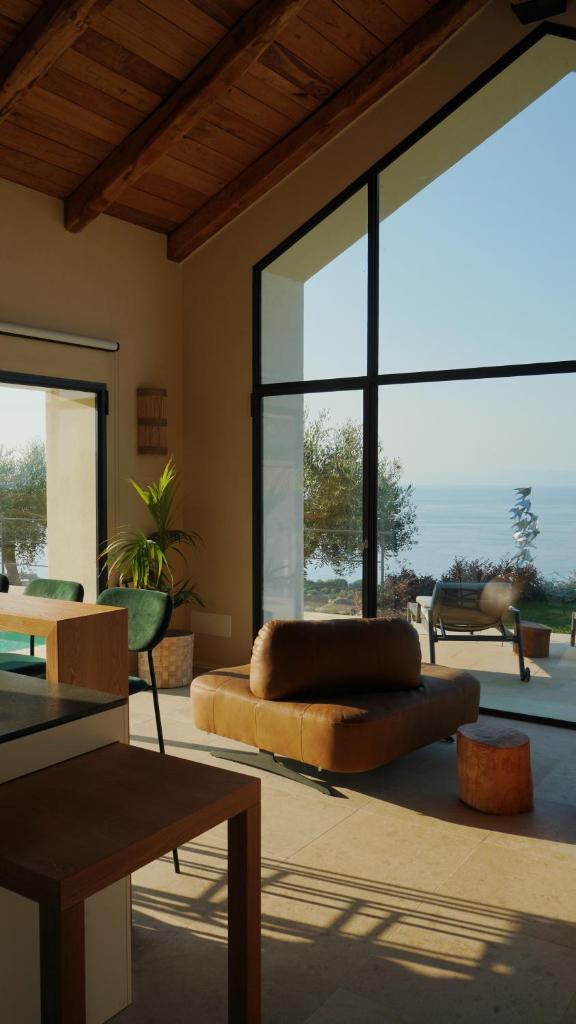 un salon avec un canapé et une grande fenêtre dans l'établissement JATU Retreat, à San Costantino