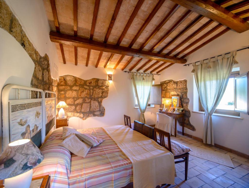 une chambre avec un lit et un mur en pierre dans l'établissement Villa I Calanchi Di Civita, à Bagnoregio 40 autres photos