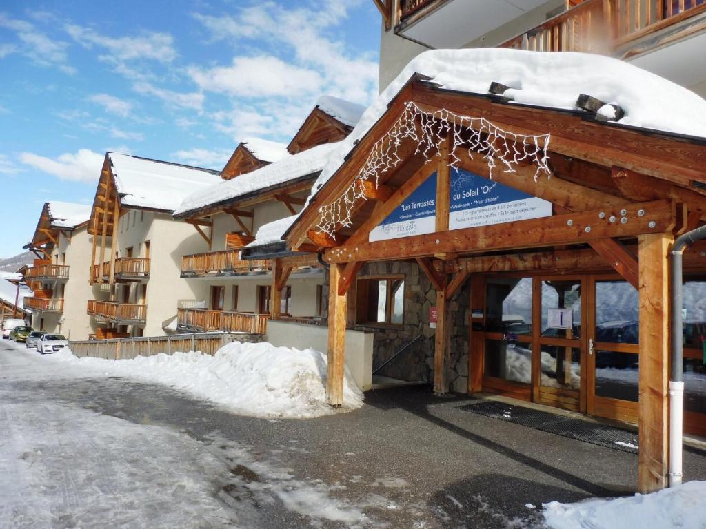 un bâtiment avec de la neige sur le toit dans l'établissement Duplex rénové - 3 CHAMBRES 8 PERS dernier étage, aux Orres