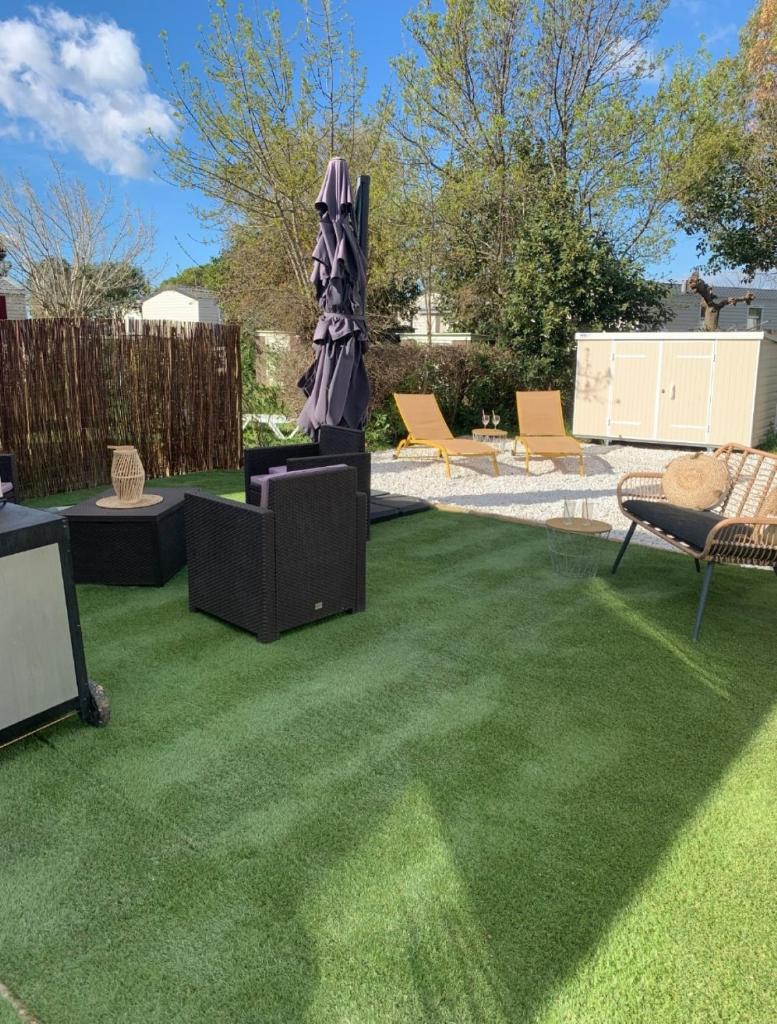 un jardin avec de l'herbe verte et une statue dans une cour dans l'établissement Cb - Espace & confort, 3 ch, 41m2, proche mer, à Lattes
