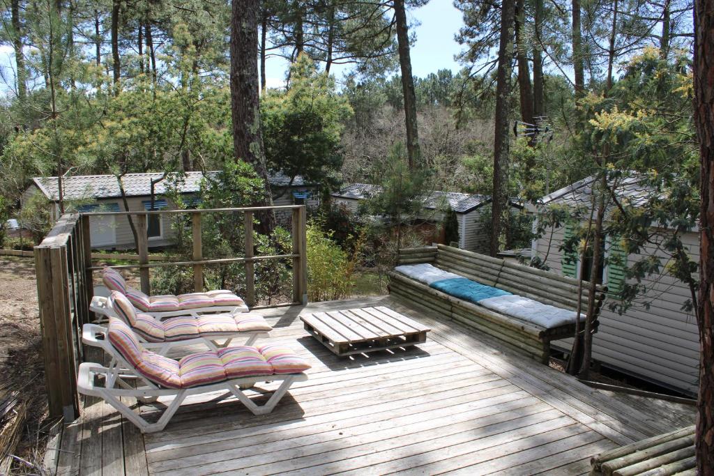 une terrasse avec deux chaises longues et un banc dans l'établissement Mobilhome Les Embruns by Siblu, à Lège-Cap-Ferret
