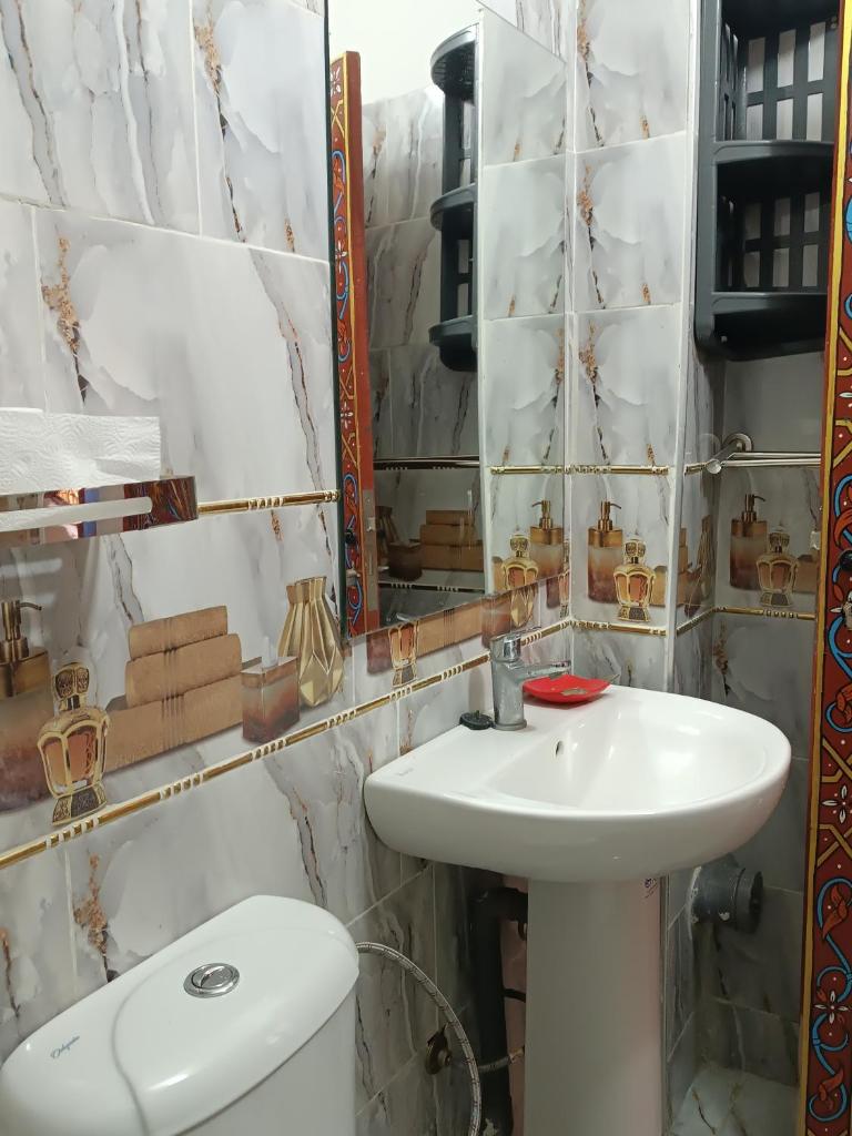 une salle de bain avec un lavabo, des toilettes et un miroir dans l'établissement Riad Safir Fes Deluxe, à Fès 37 autres photos