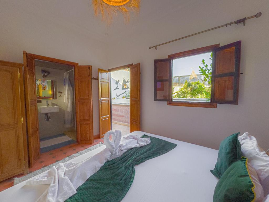 une chambre avec un lit et une salle de bain avec douche dans l'établissement Riad L'Orchidée Suites & Spa, à Marrakech