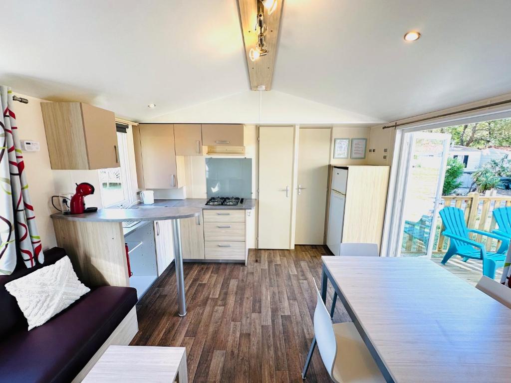 une cuisine et un salon avec un canapé et une table dans l'établissement Mobile home op camping de Pujol in Argeles-Sur-Mer, à Argelès-sur-Mer