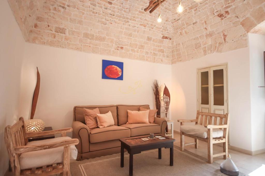 un salon avec un canapé et une chaise dans l'établissement TD I Pagliericci - Enjoy Trulli with Pool, à Monopoli