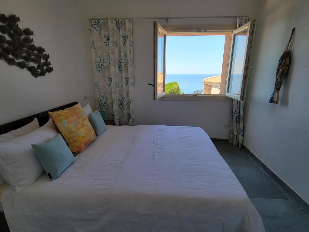 un grand lit dans une chambre avec une fenêtre dans l'établissement Villa SUNSET VIEW, à Costa Paradiso