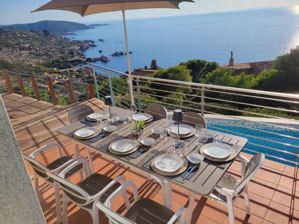- une table avec des chaises et un parasol sur le balcon dans l'établissement Villa SUNSET VIEW, à Costa Paradiso