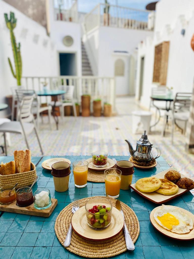 - une table avec des aliments pour le petit-déjeuner et des verres de jus d'orange dans l'établissement Riad l'Ayel d'Essaouira, à Essaouira 29 autres photos